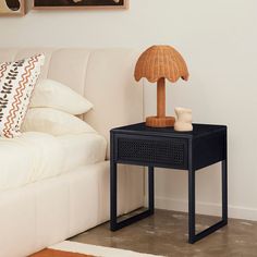 a small table with a lamp on it next to a white couch in a living room