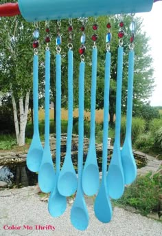 several blue spoons hanging from the side of a pole