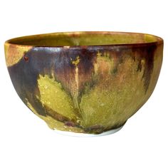 a brown and green bowl sitting on top of a white table