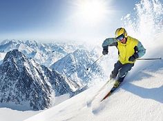 a man riding skis down the side of a snow covered slope