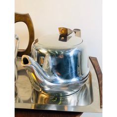 a silver tea pot sitting on top of a metal tray