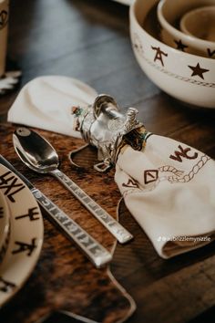 the table is set with silverware and napkins, including spoons and forks