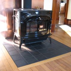 a black stove sitting on top of a hard wood floor