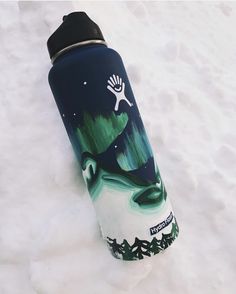 a water bottle sitting in the snow with an image of a person jumping up into the air