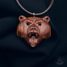 a wooden necklace with a bear head on it