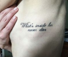 a person with a tattoo saying what's inside he never dies on their chest