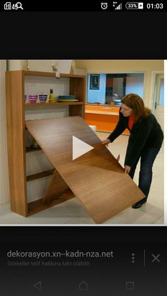 a woman standing next to a wooden shelf