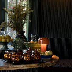 a table topped with vases filled with flowers and fruit