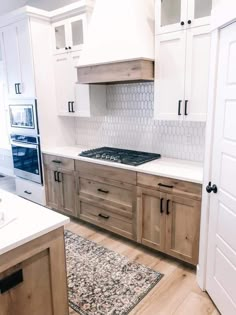 a kitchen with white cabinets and wood flooring is pictured in this image from the front door