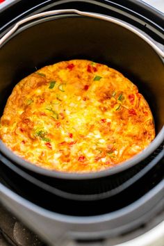 a close up of a cooked pizza in an electric crock pot on the stove