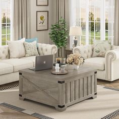 a living room filled with furniture and a laptop computer on top of a coffee table