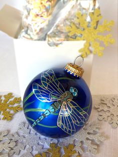 a blue ornament sitting on top of a table next to snowflakes