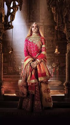 a woman in a red and gold bridal outfit