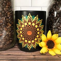 a coffee mug sitting on top of a wooden table next to two sunflowers