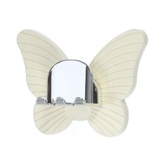 a white butterfly shaped mirror mounted to the side of a wall