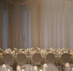 the tables are set up with white linens and lit candles for an elegant wedding reception