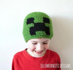 a young boy wearing a crocheted hat with an angry green frog on it