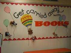 a room with a sign that says get organized with books and balloons on the wall