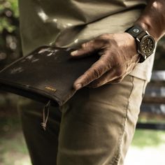 a man is holding his wallet in one hand and wearing a watch on the other