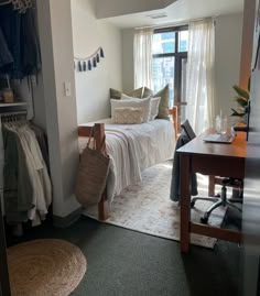 a bedroom with a bed, desk and chair next to a window in the room