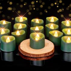 many lit candles are arranged in rows on a wooden stand and surrounded by other small ones