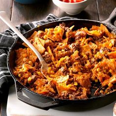 a large skillet filled with meat and vegetables