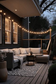 an outdoor living area with patio furniture and string lights strung over the back porch deck