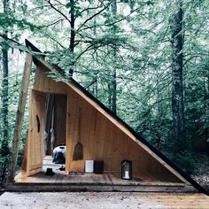 a small wooden cabin in the woods surrounded by trees