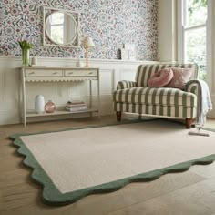 a living room with a couch, chair and rug on the floor in front of a window