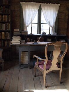 an old fashioned desk and chair in front of a window