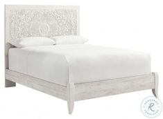 a white bed with an intricate headboard and foot board