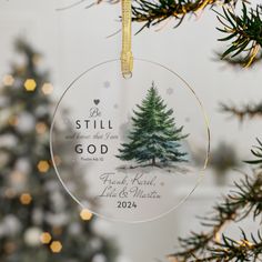 a christmas ornament hanging from a tree with the words, be still god