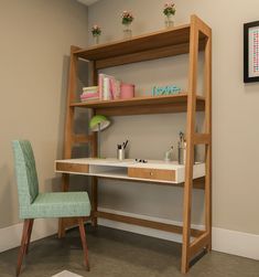 a desk with a chair next to it and a shelf on the wall behind it