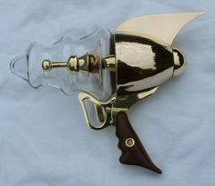 a gold colored hair dryer sitting on top of a white sheet with a wooden handle