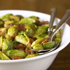 a white bowl filled with brussel sprouts and bacon