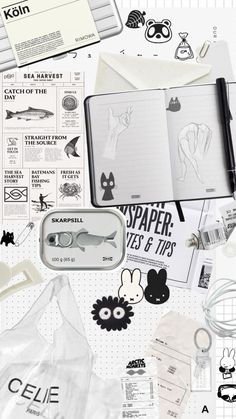 an open notebook surrounded by stickers, scissors and other items that are on the table