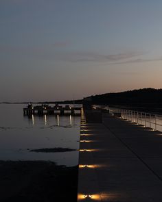 the pier is lit up at night with lights on