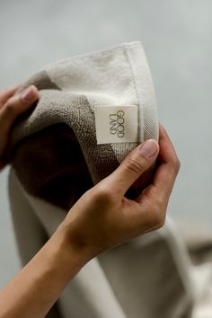 a person holding onto a cloth with the label on it