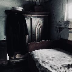 an old fashioned bedroom with a bed and cupboard