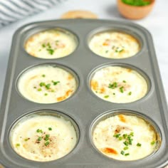 a muffin tin filled with baked food on top of a wooden cutting board