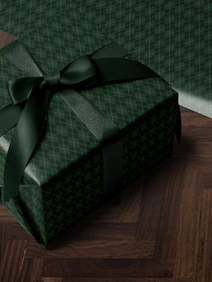 a green wrapped present sitting on top of a wooden floor