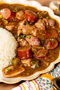 a white plate topped with rice and meat covered in gravy on top of a table