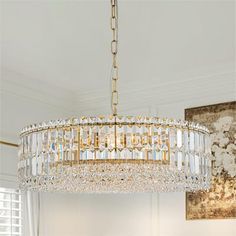 a chandelier hanging from the ceiling in a room with white walls and windows