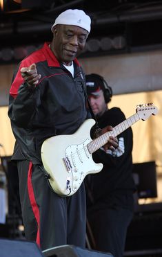 a man with a white guitar on stage