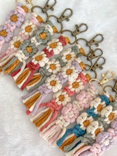 several crocheted keychains with metal hooks attached to them on a white surface