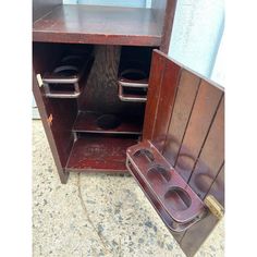 an old wooden cabinet with two toilets in the bottom and one on the inside, sitting outside