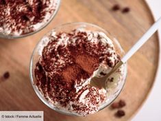 two desserts with chocolate and powdered sugar in them on a wooden table top