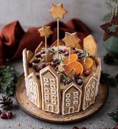 a decorated christmas cake with orange slices and stars on top, surrounded by other decorations