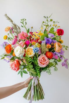 a person holding a bouquet of colorful flowers