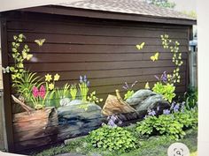 a painting of flowers and butterflies on the side of a wooden building with grass in front of it